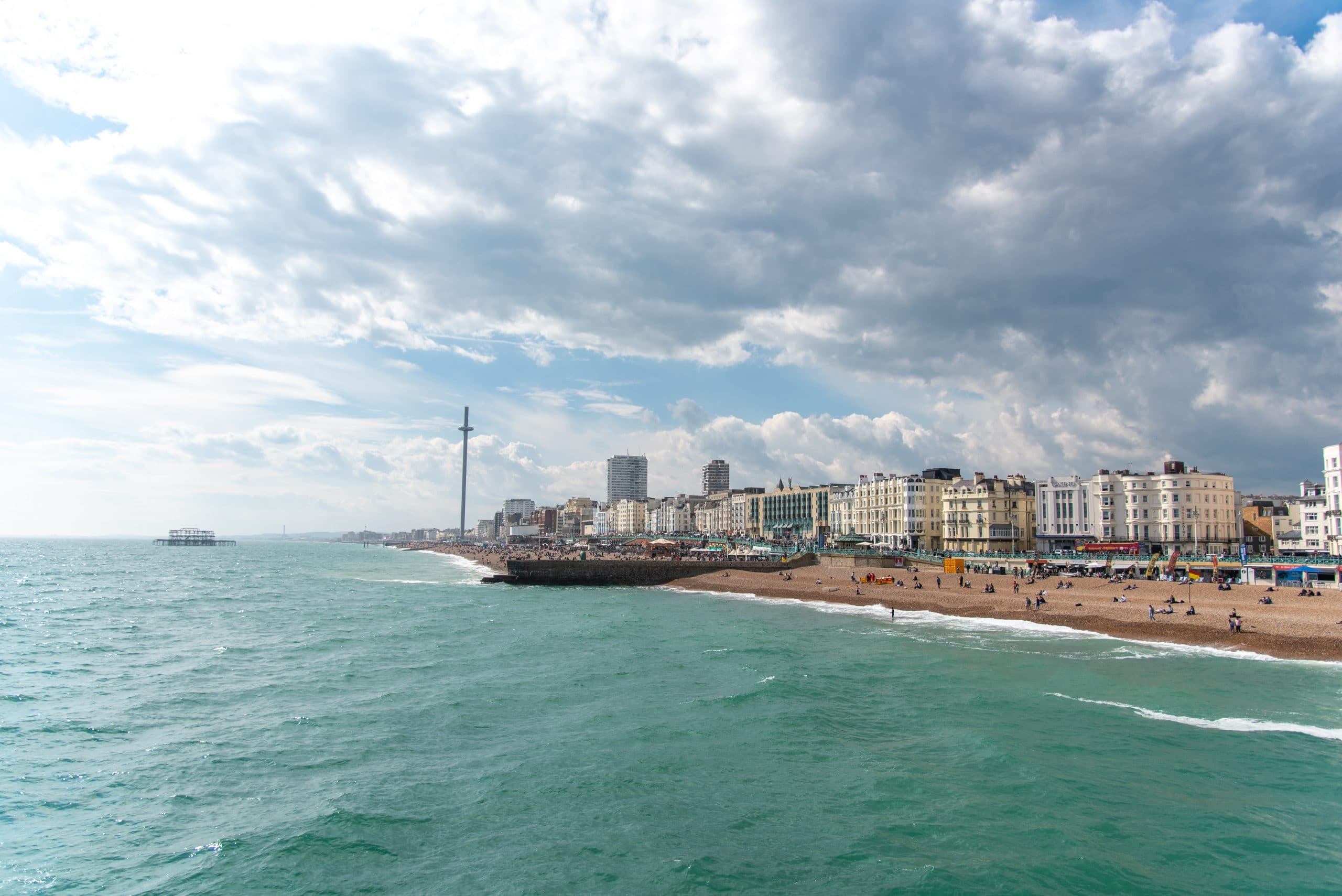 Brighton seafront on a cloudy day with the pier and beach in clear view.