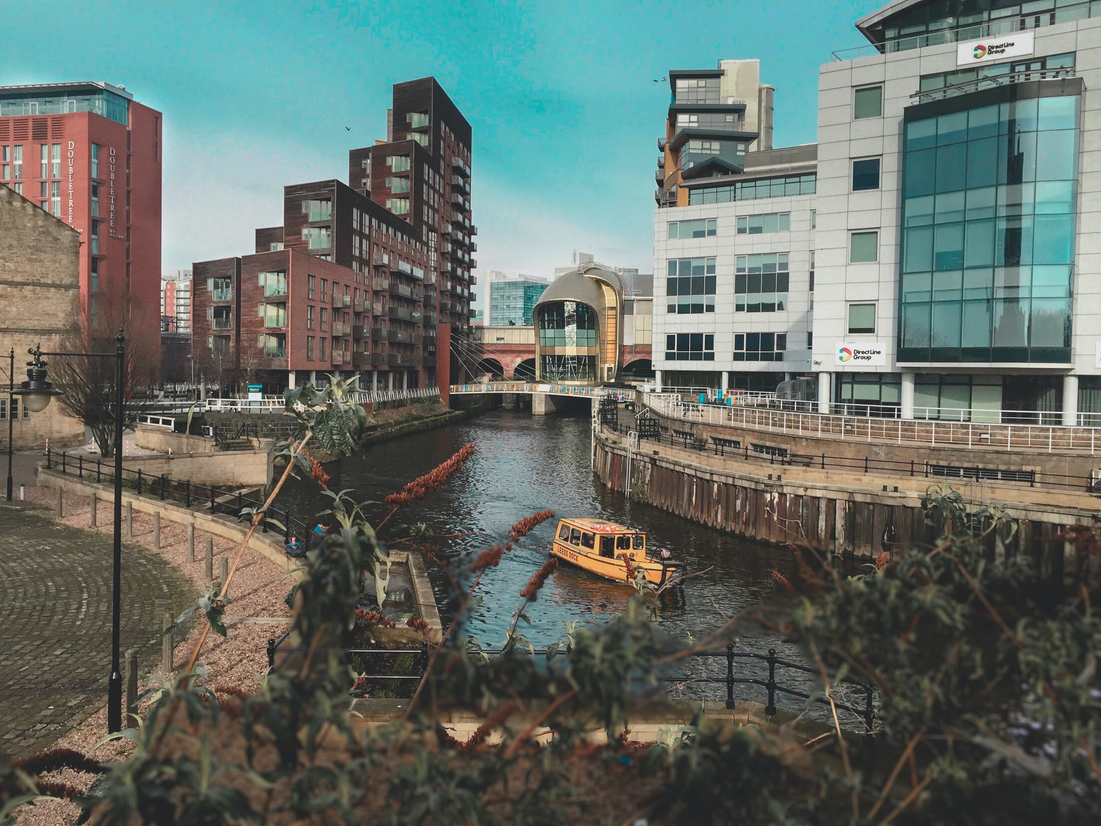 The River Aire running through Leeds city centre with office blocks and apartments either side.