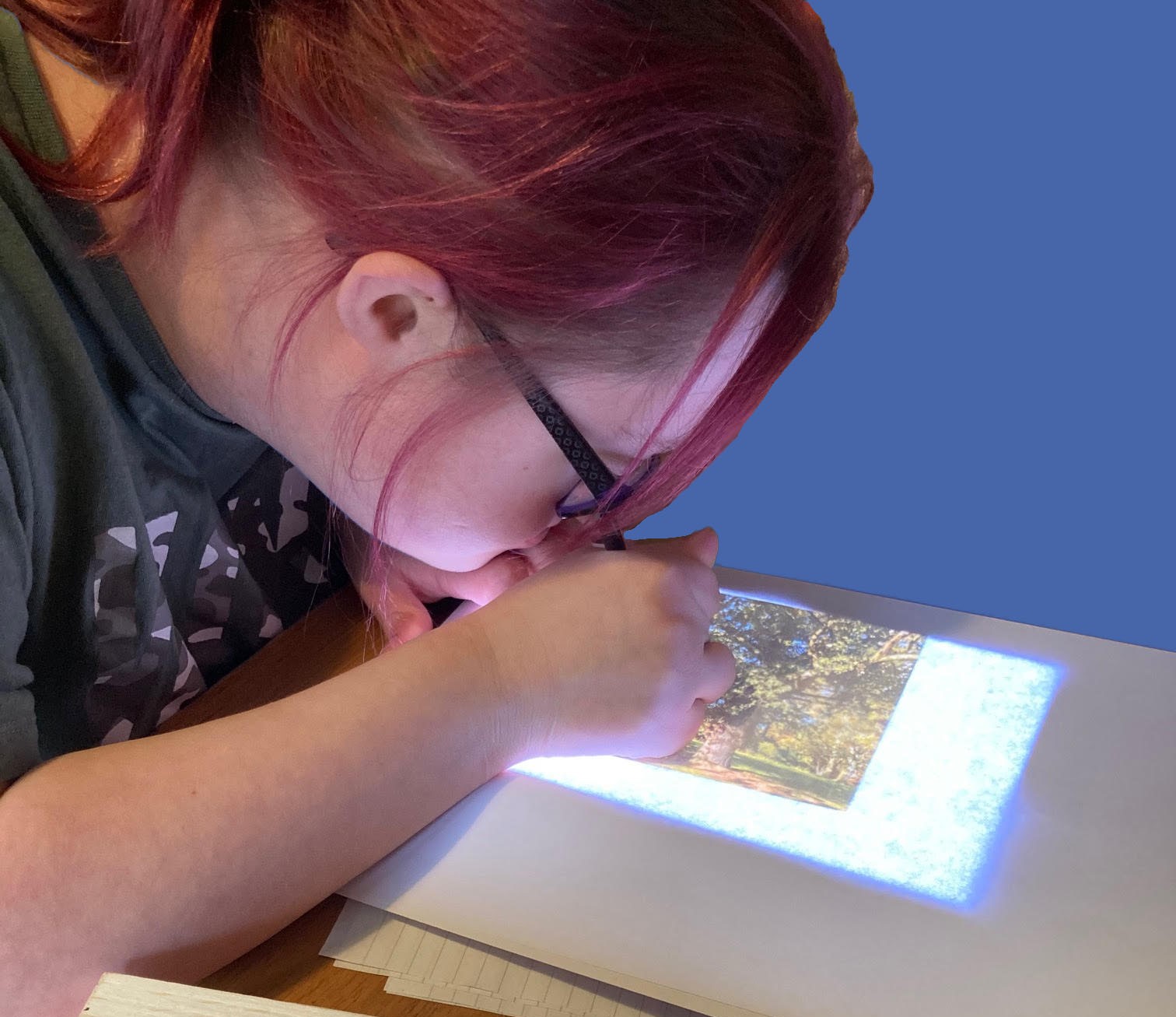 An Able Arts artist is drawing on a screen in front of her.